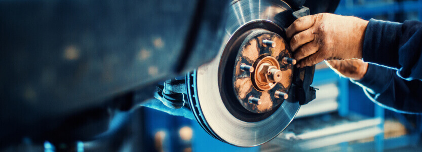 Photo of a close up from a worker on the assembly line in an automotive production having his hand on a piece of technology